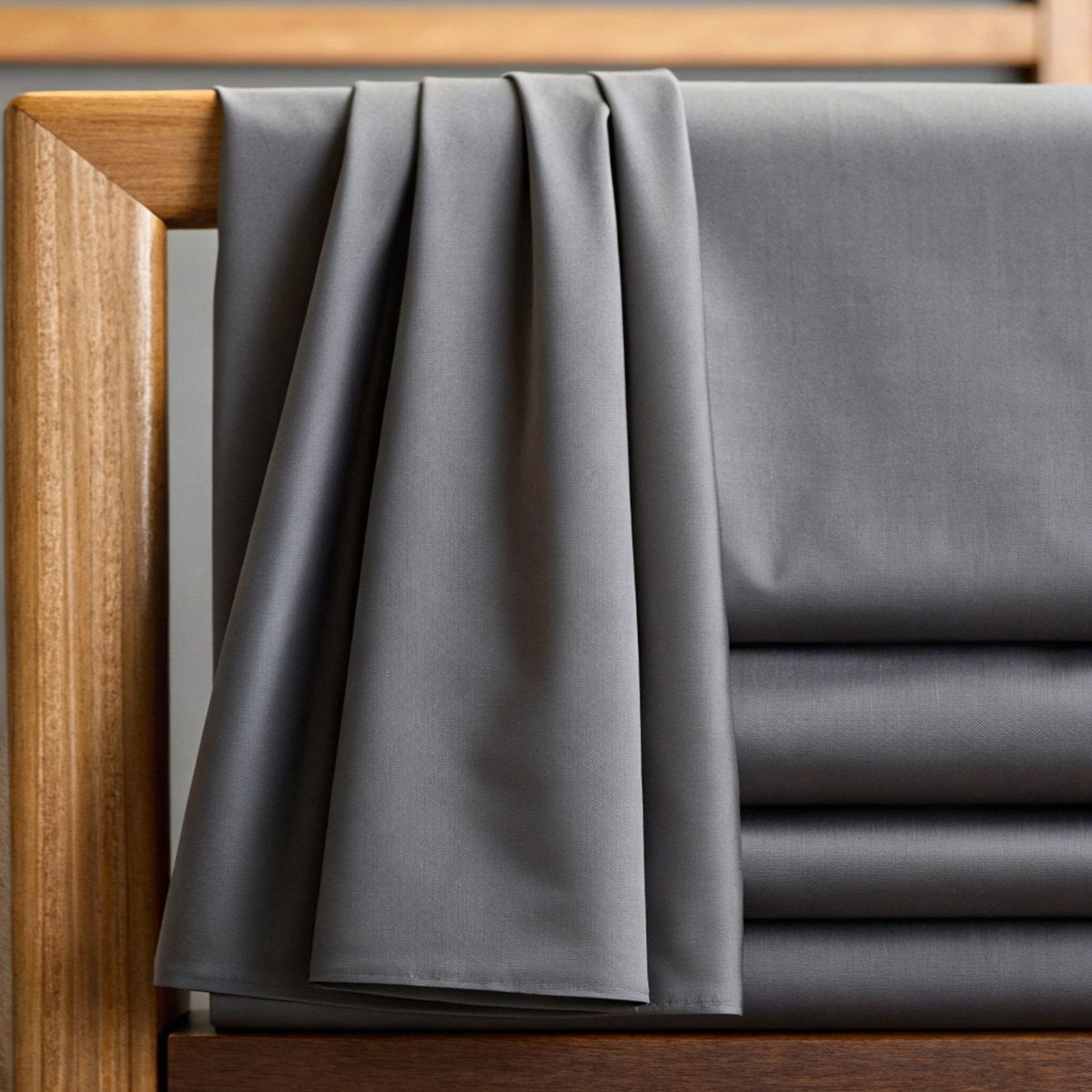 Gray bamboo sheet set with fitted and flat sheets, neatly draped at the bed edge.