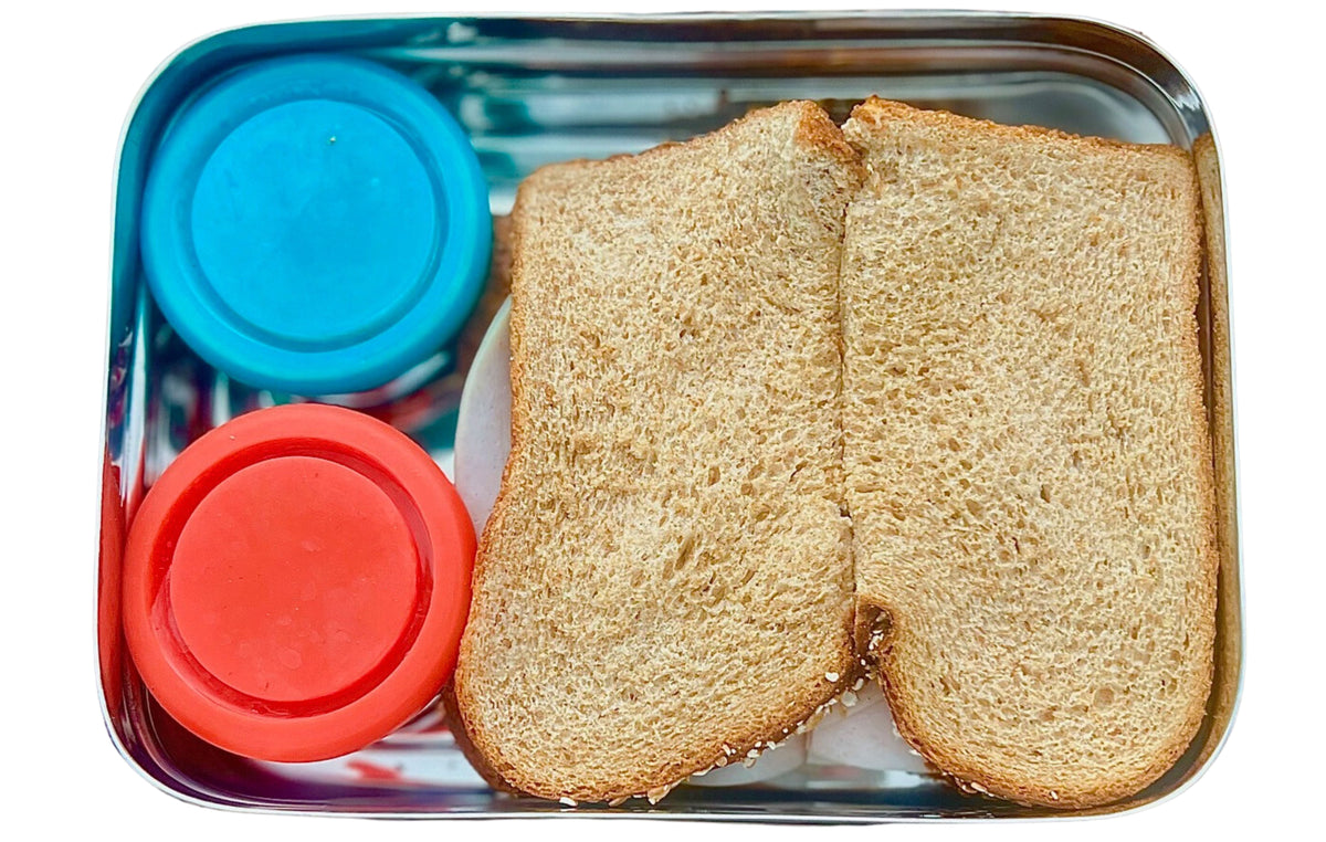 Stainless steel bento tray with two bread slices and blue and red silicone snap lids