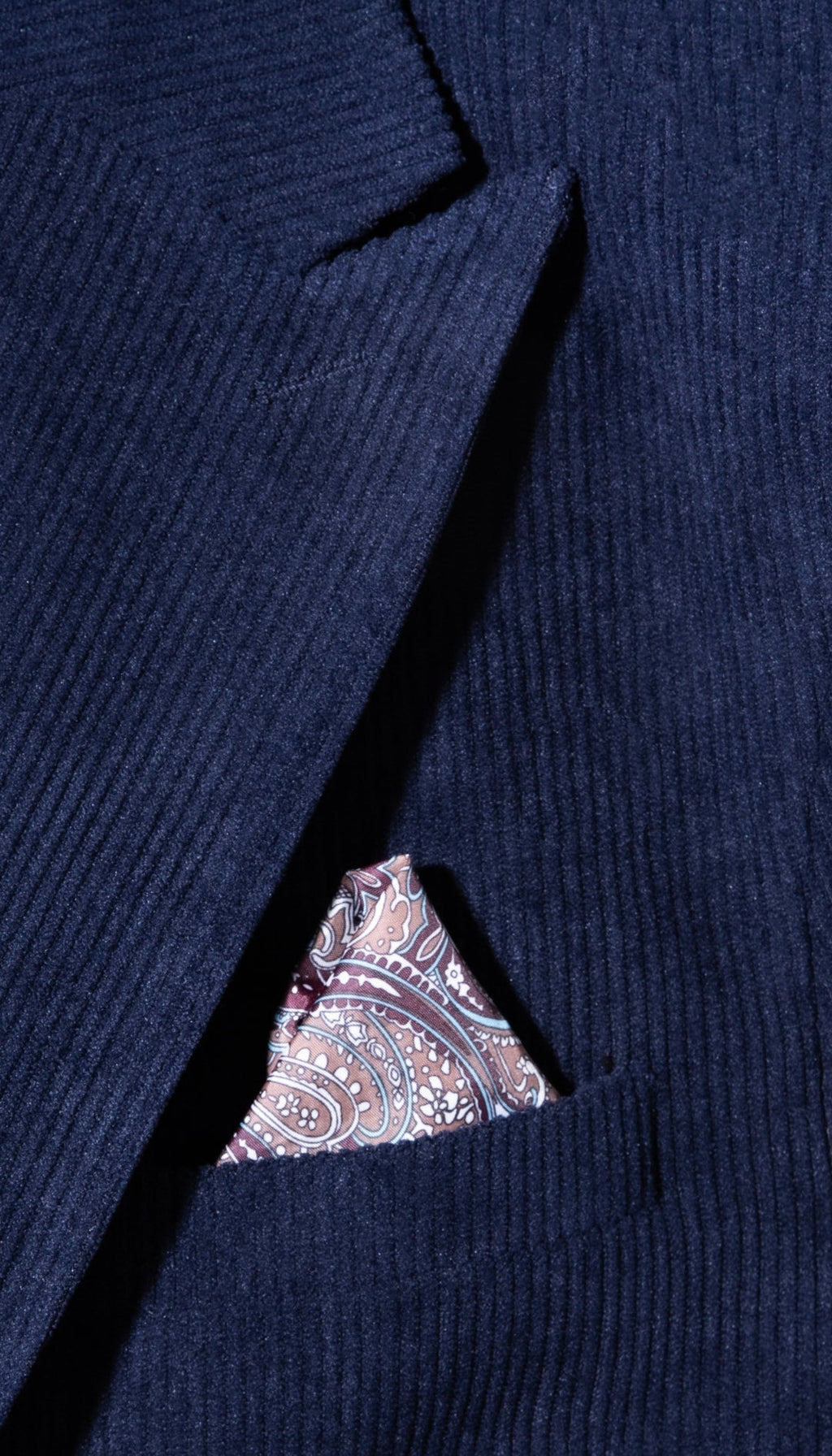 Navy corduroy suit jacket chest pocket with paisley pocket square