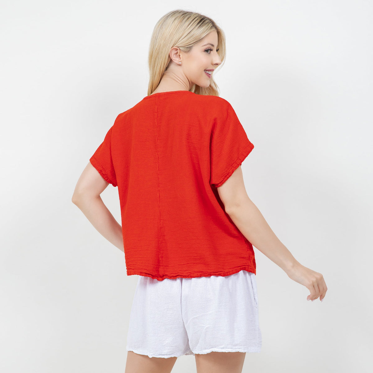 Back view of red cotton gauze top with short sleeves and rounded hem