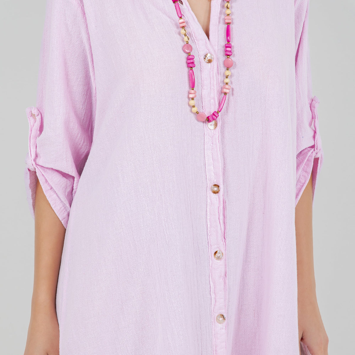 Light pink cotton gauze tunic detail, vertical button placket and open collar.