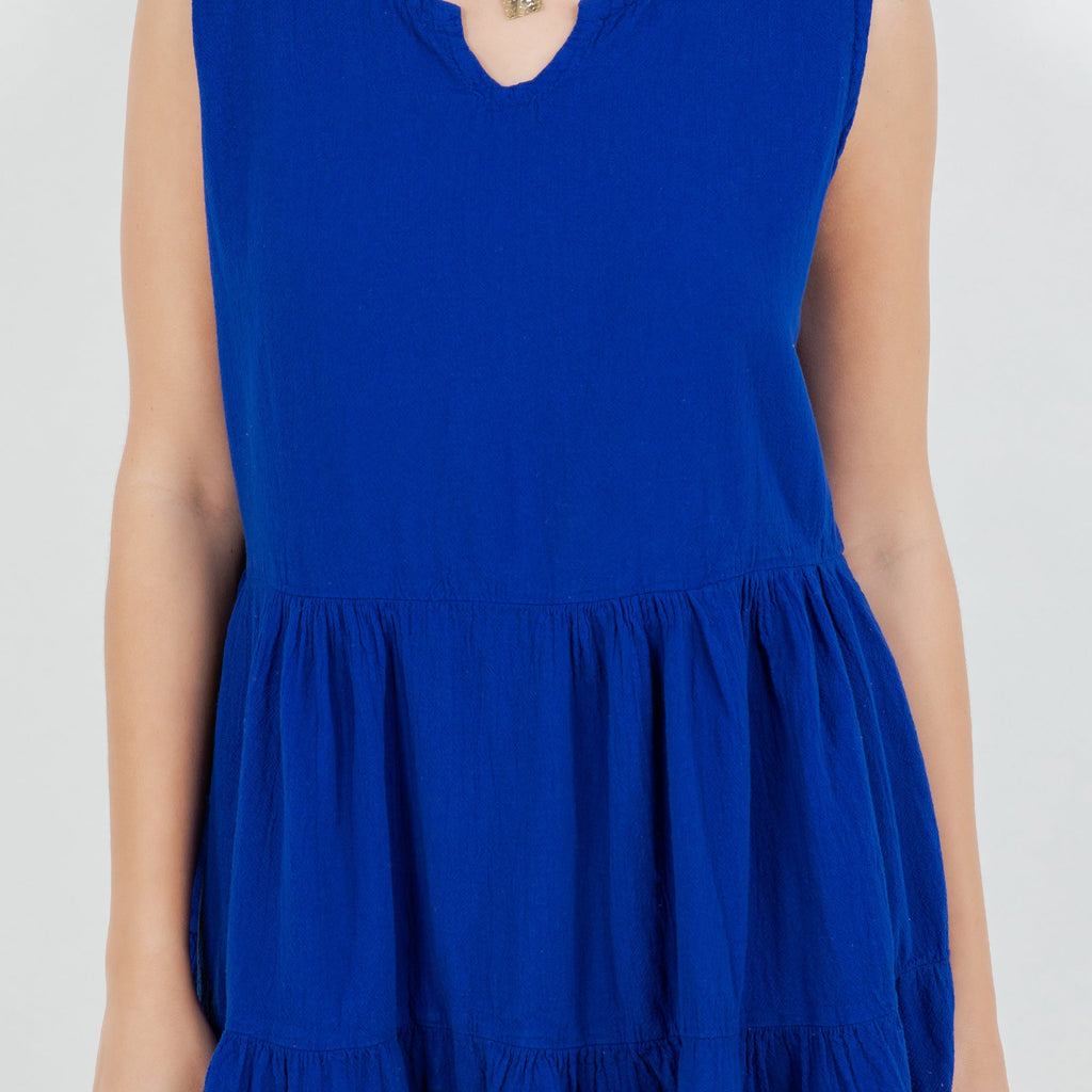 Close-up of blue cotton gauze tiered sleeveless dress, gathered waist