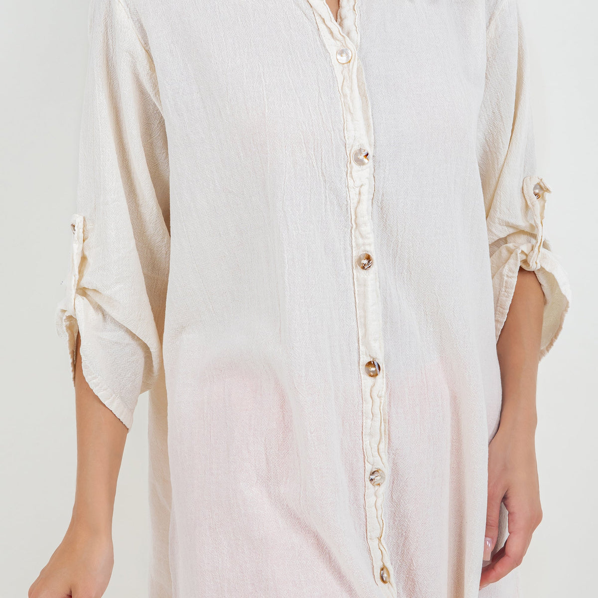 Off-white cotton gauze tunic close-up with pointed collar and button placket