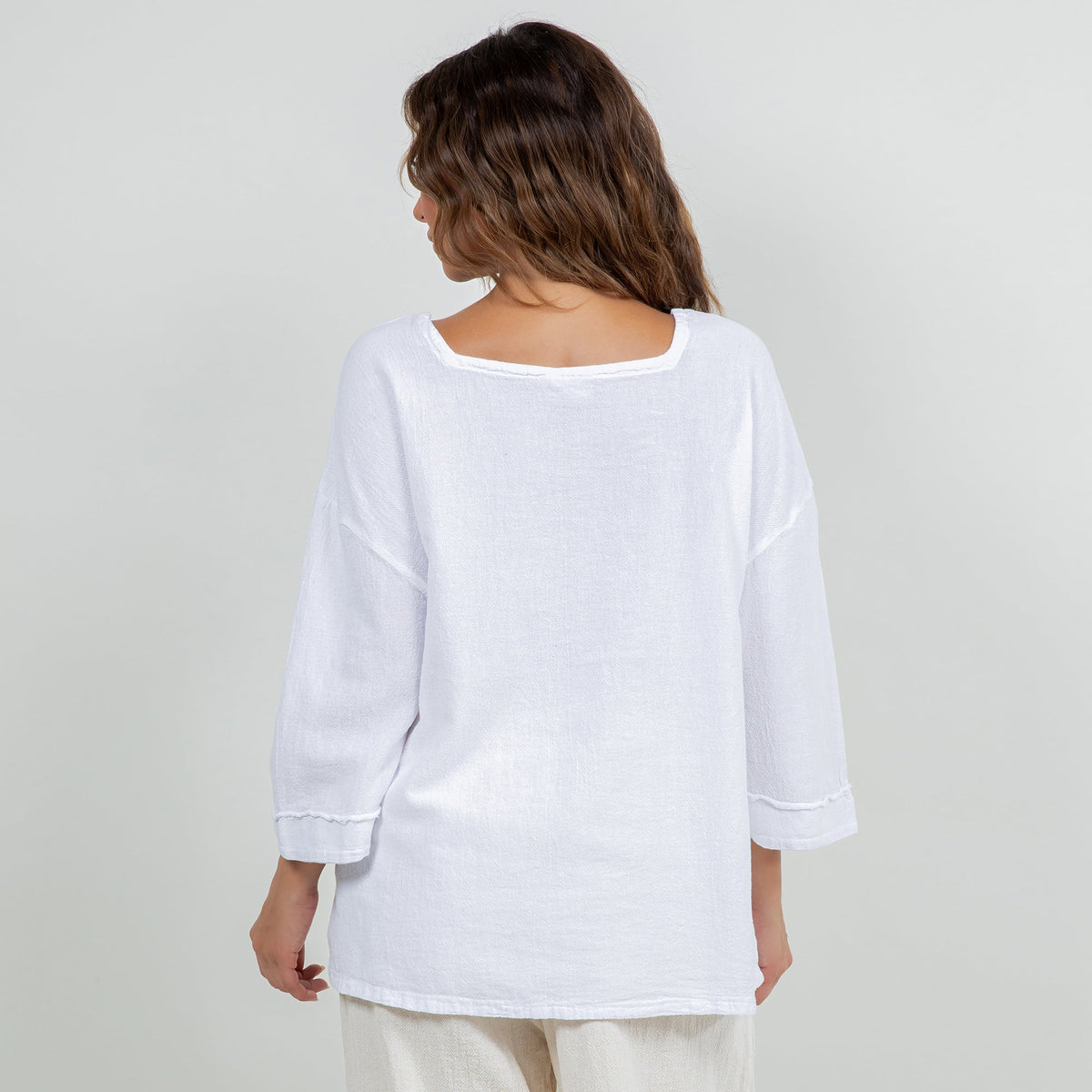 White cotton gauze peasant top, back view with 3/4 sleeves and rounded hem