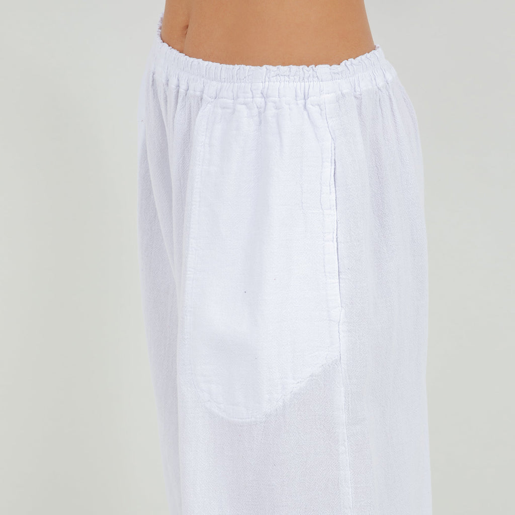White cotton gauze pants with elastic waistband and subtle vertical seam detail