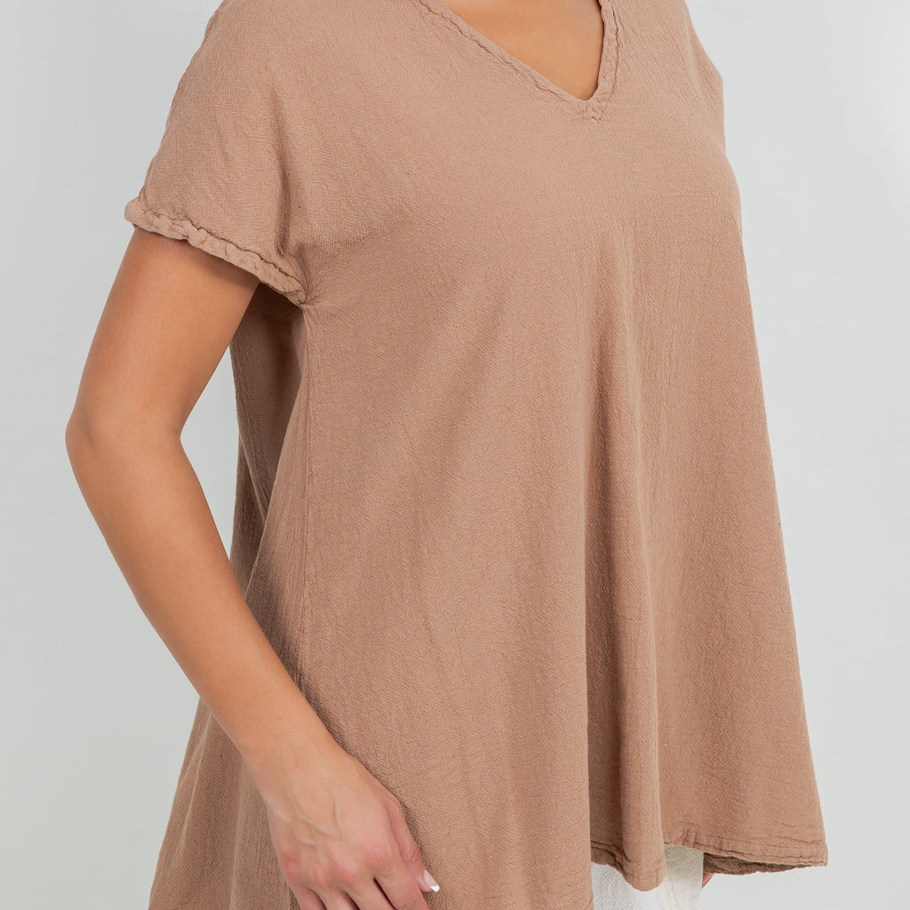 Close-up of brown cotton gauze top fabric with V-neck and short rolled sleeve