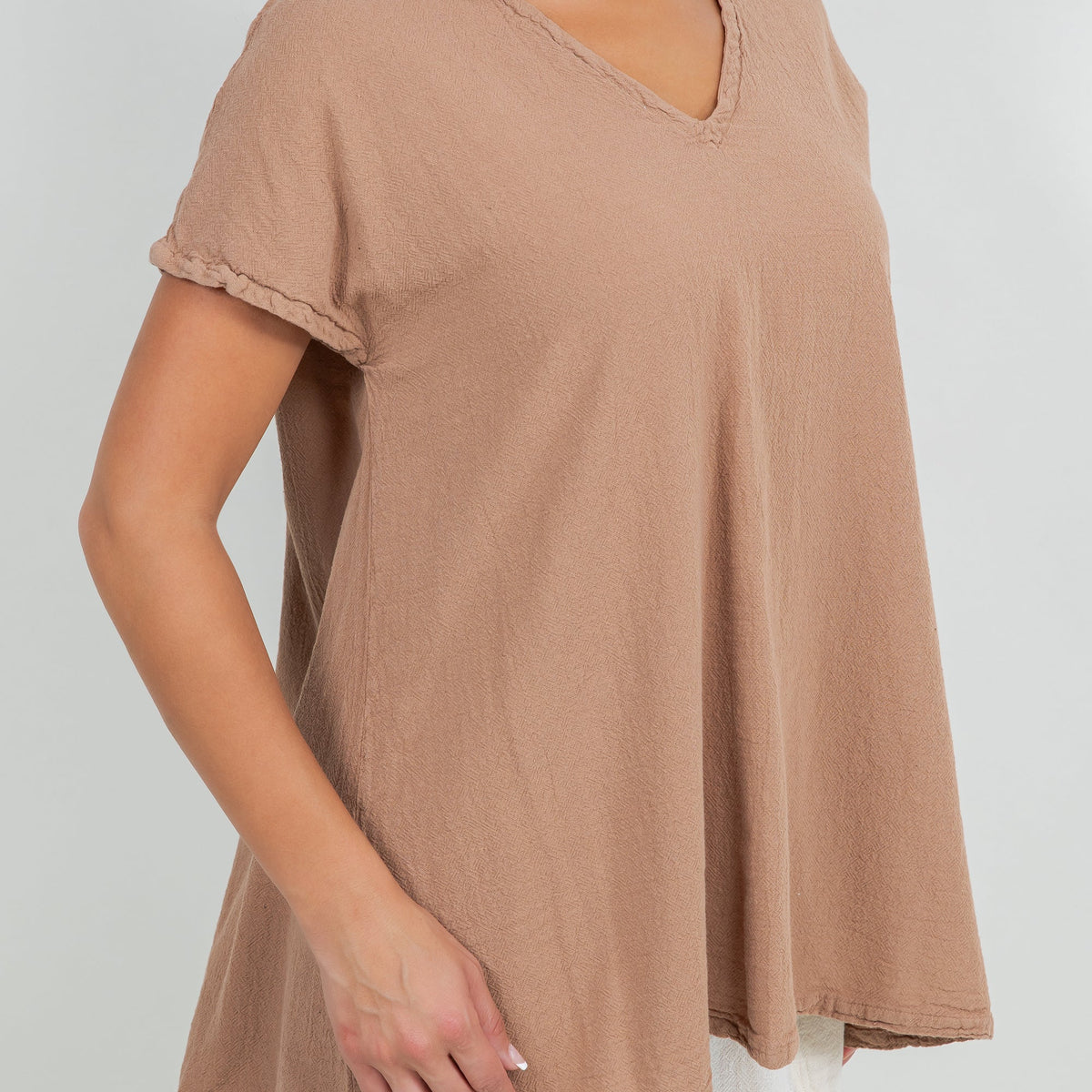 Close-up of brown cotton gauze top fabric with V-neck and short rolled sleeve