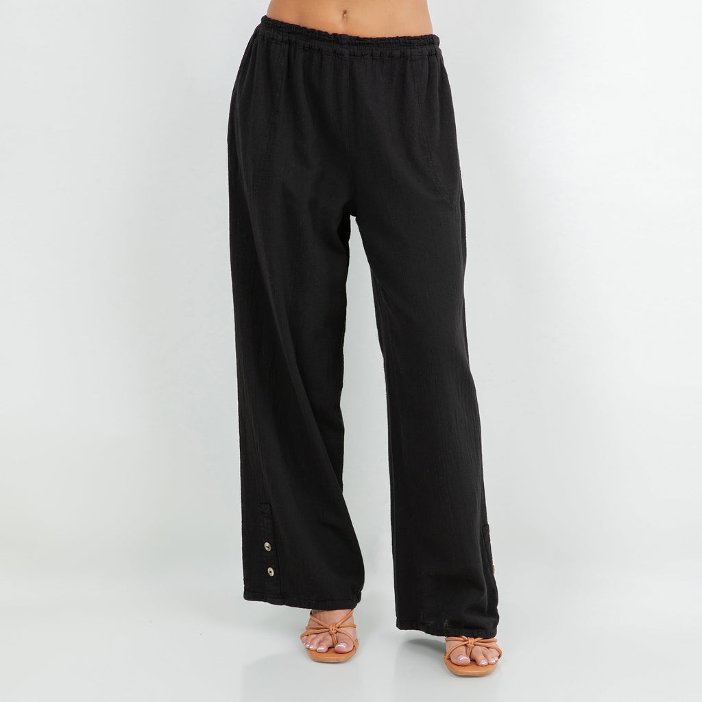 Black cotton gauze pants with elastic waistband, wide legs, and side button accents