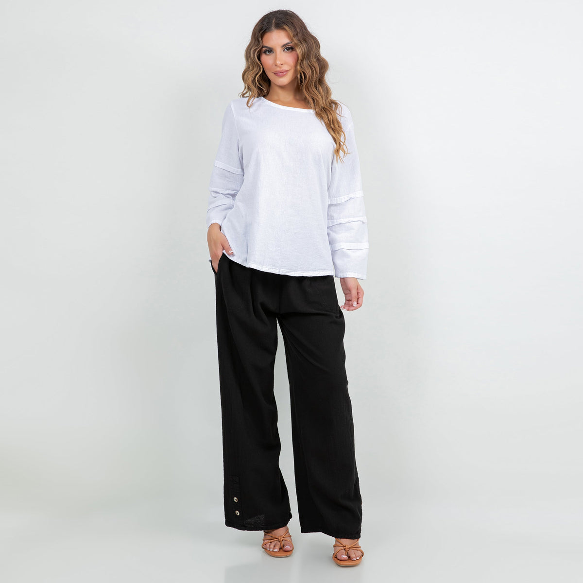 Black cotton gauze pants with elastic waistband, wide legs, and side button detail