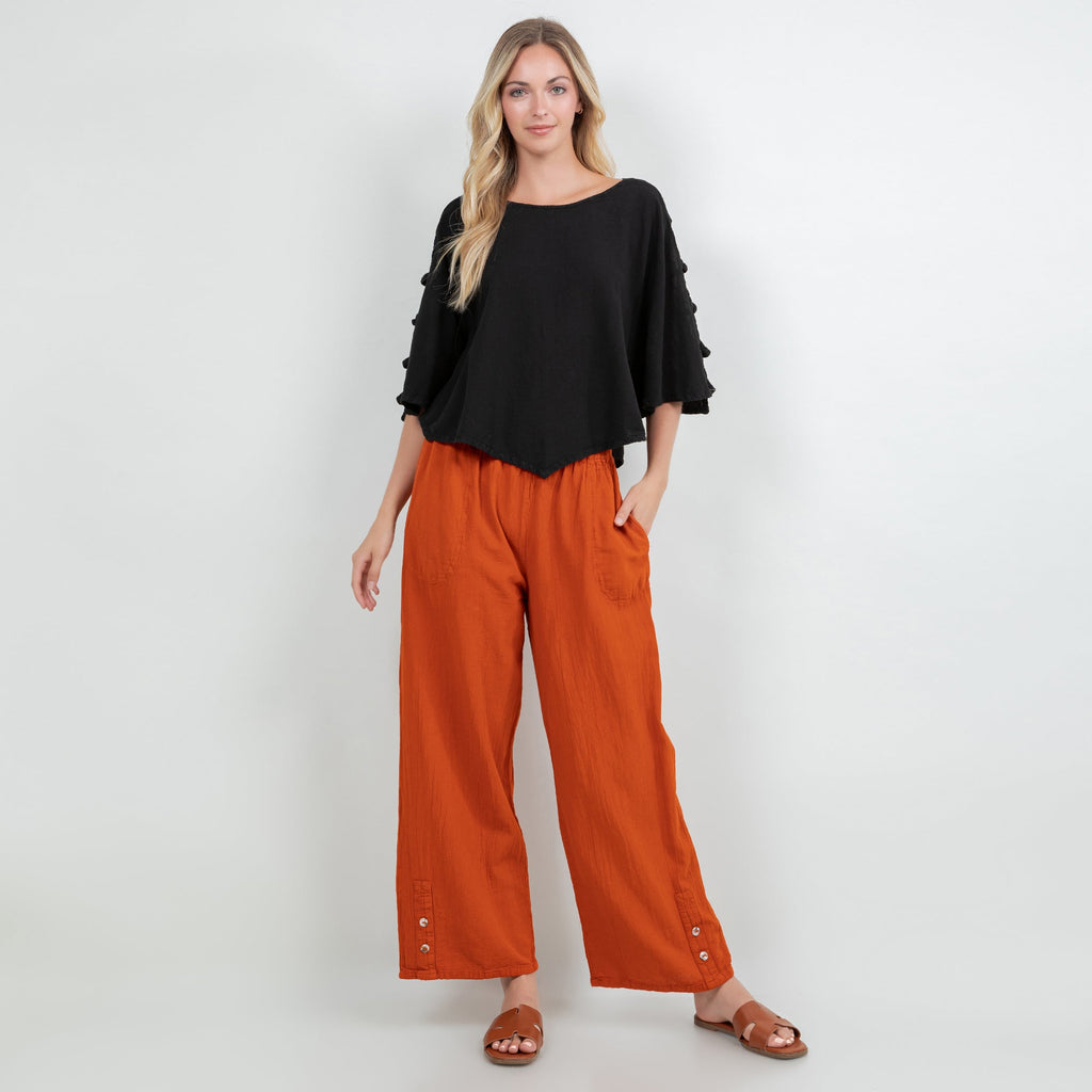Orange cotton gauze pants with elastic waist, roomy wide legs, side pockets, buttoned cuffs