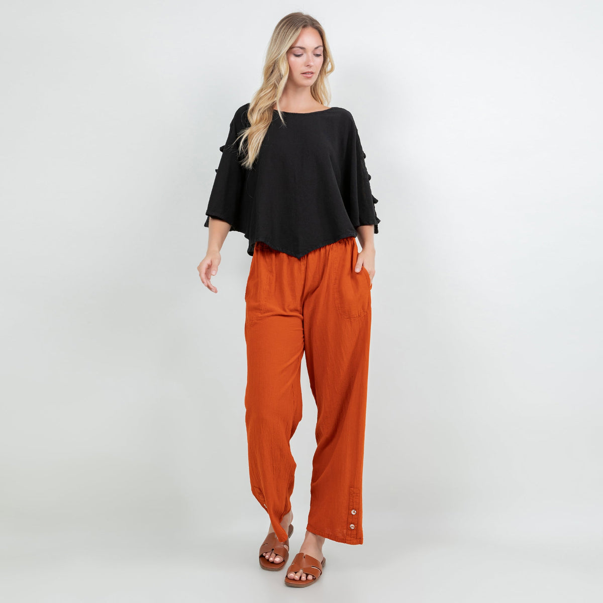 Orange cotton gauze wide-leg pants with elastic waistband, side pockets, and buttoned hem cuffs