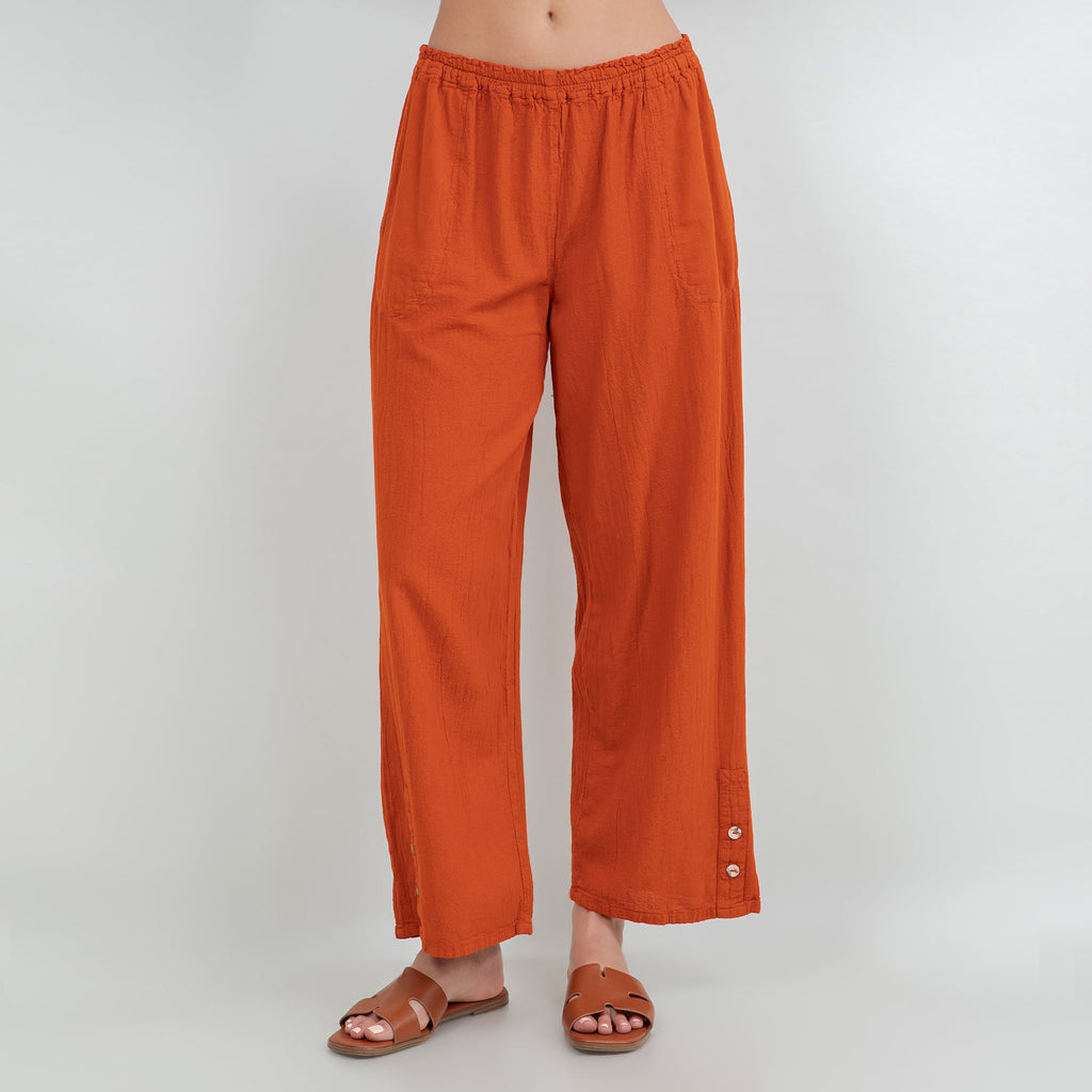 Orange cotton gauze pants with elastic waist, relaxed wide leg, ankle length, side buttons at hem