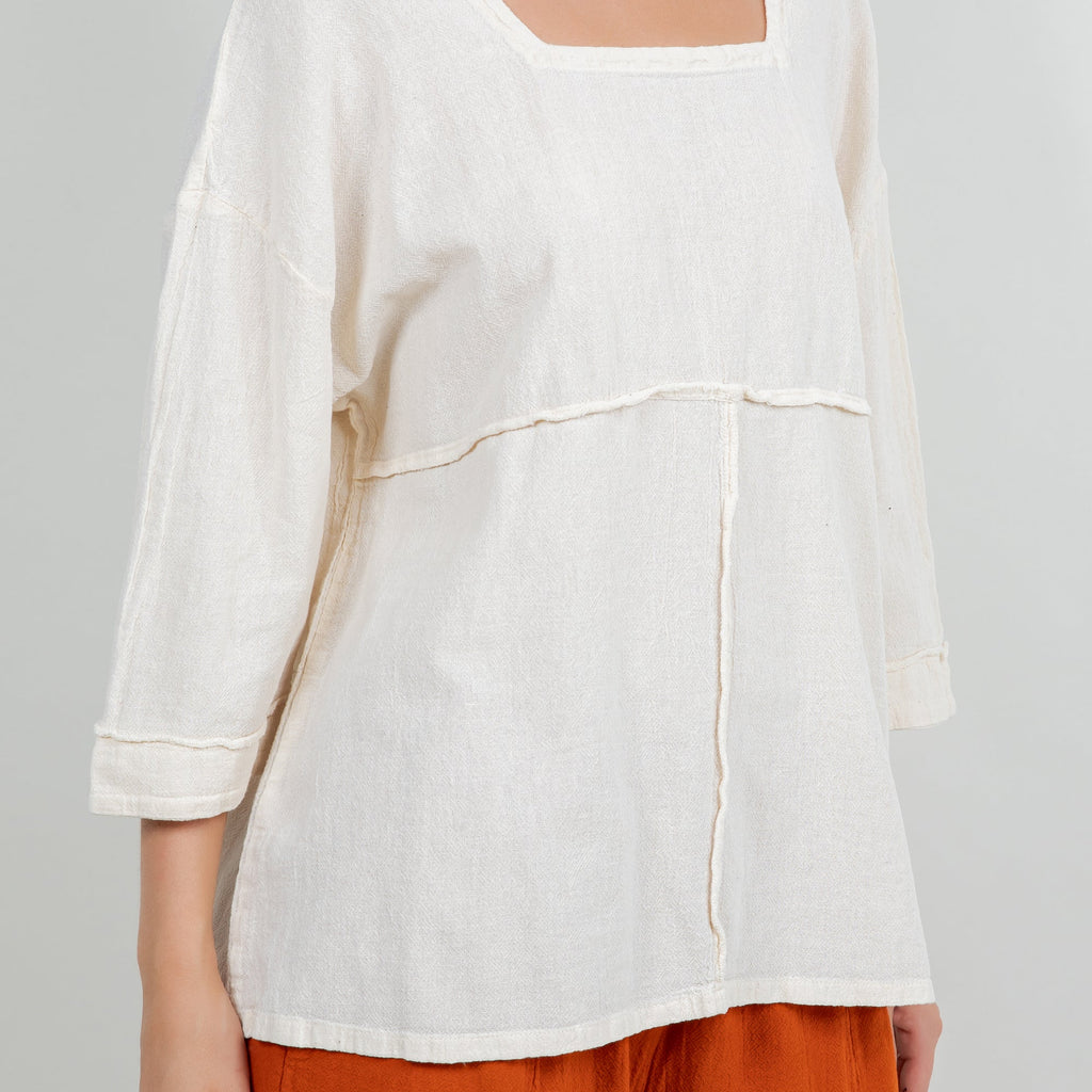 White cotton gauze top close view with square neck and curved seam across chest