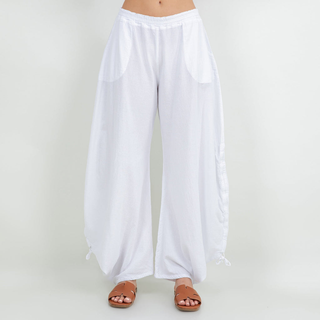 White cotton gauze wide-leg pants with elastic waist, pocket-like panels, tied hems