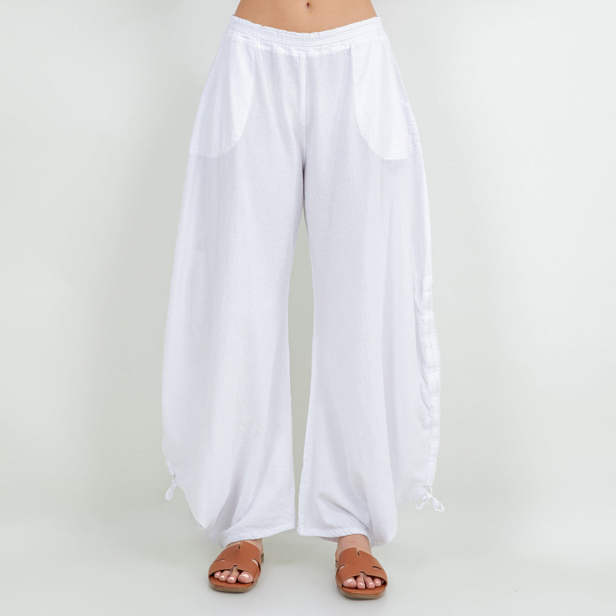 White cotton gauze wide-leg pants with elastic waist, pocket-like panels, tied hems