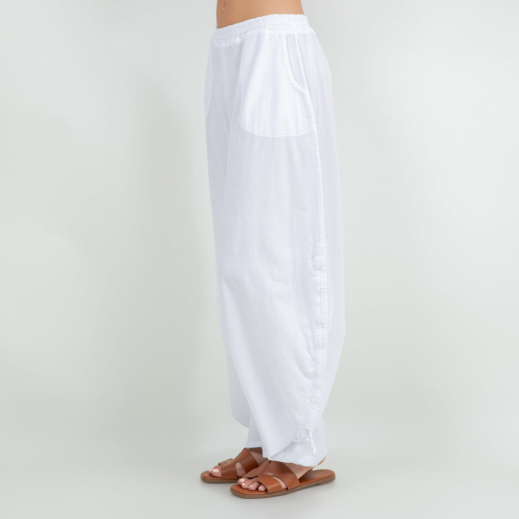 White cotton gauze wide-leg pants with elastic waistband and tied tassel hems
