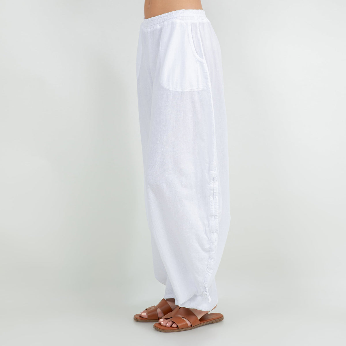 White cotton gauze wide-leg pants with elastic waistband and tied tassel hems