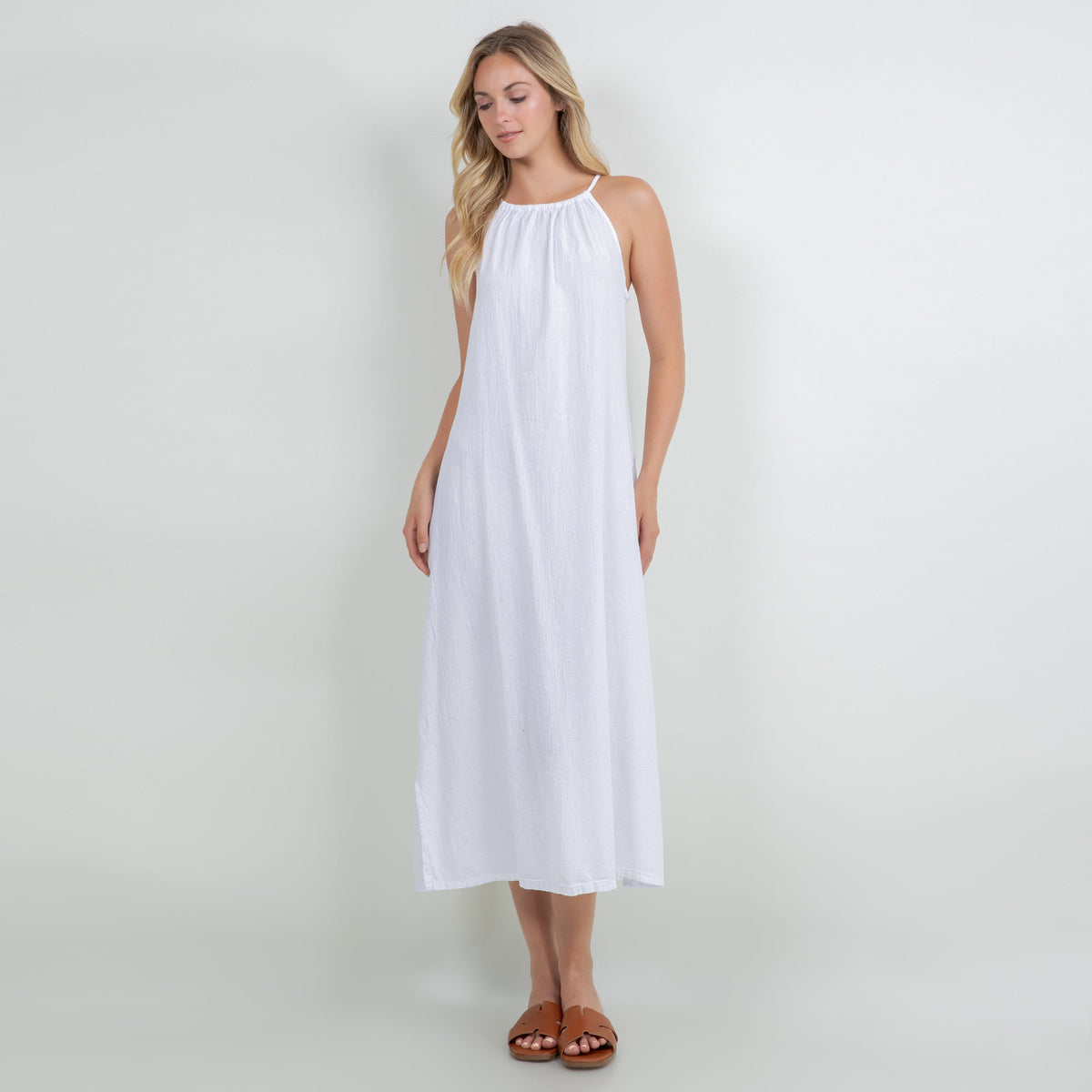 White cotton gauze sleeveless halter midi dress with gathered neckline and slit hem.