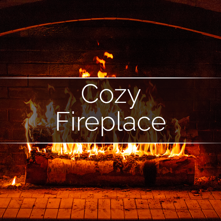 Fireplace-scented soy wax candle with lit flame on hearth