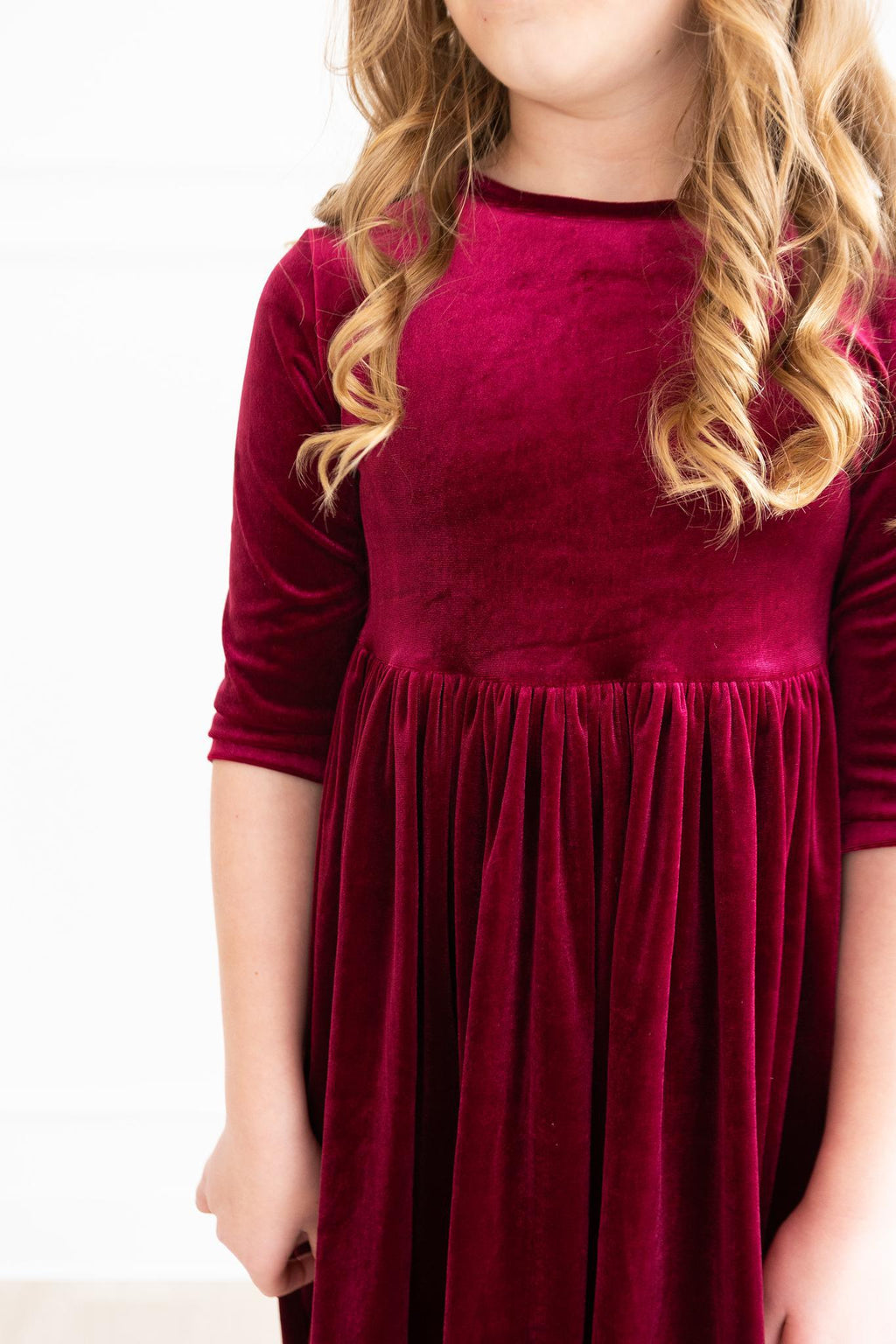 Cranberry velvet bodice with gathered waist and pleated skirt detail