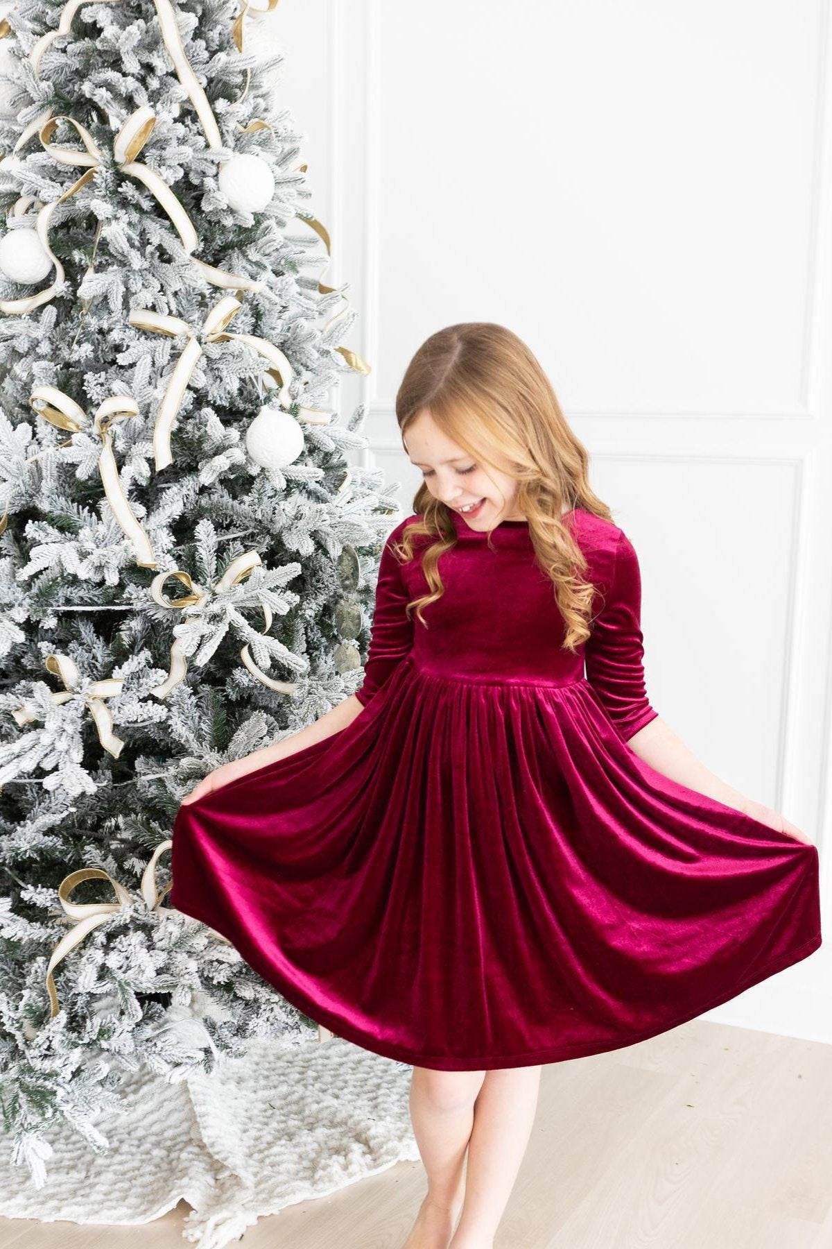 Cranberry velvet twirl dress with three-quarter sleeves and gathered skirt