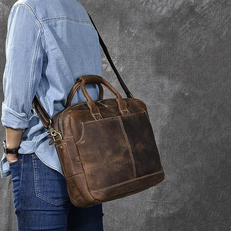 Vintage brown leather messenger bag with zipper closure and front slip pocket