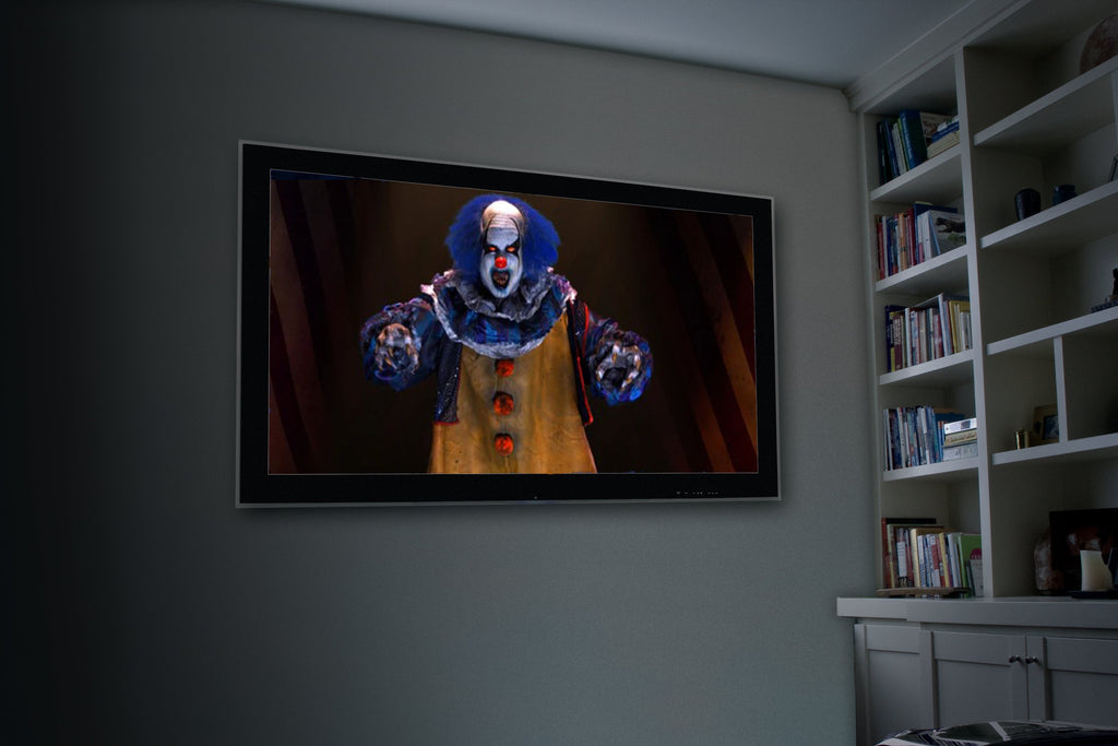 Wall-mounted projection showing a blue and red clown face graphic