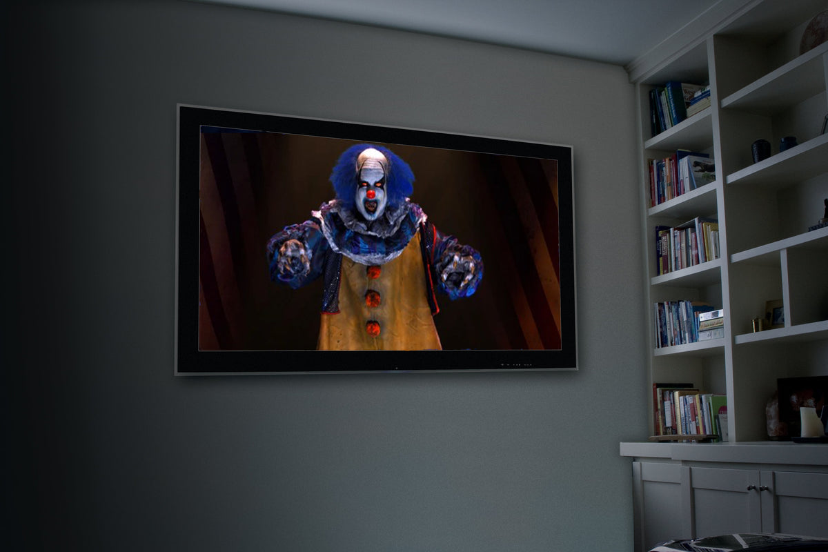 Wall-mounted projection showing a blue and red clown face graphic