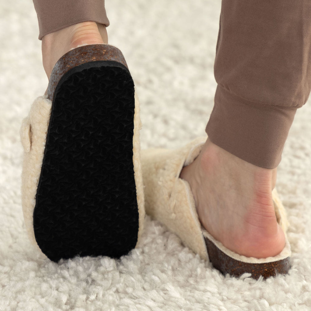 Cream plush clog slippers with paw-print appliques and black textured sole
