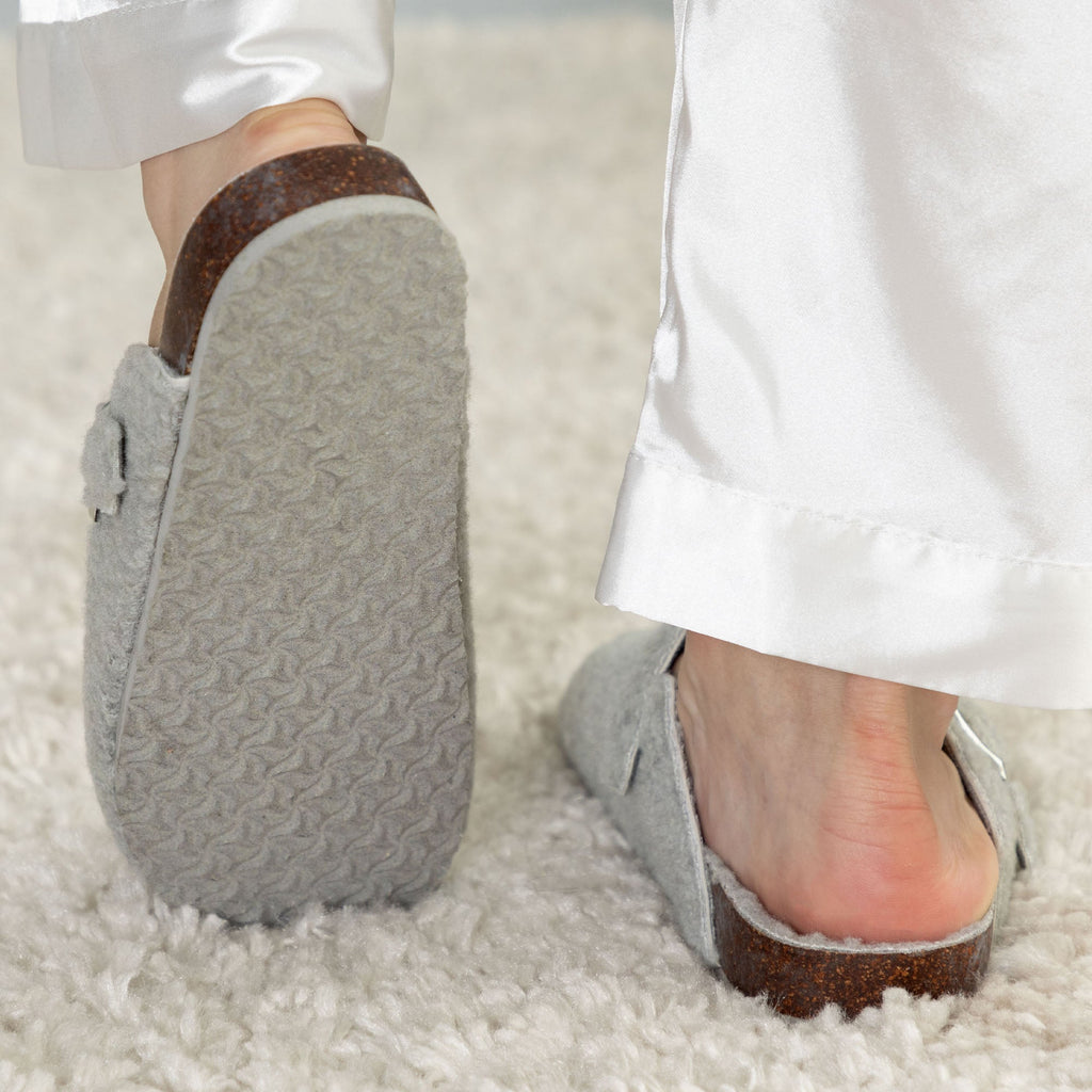 Gray plush sherpa clog slippers with brown sole trim and soft textured side panels