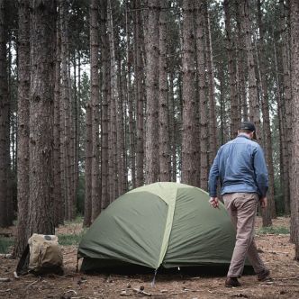 Olive green backpack on person walking in the woods