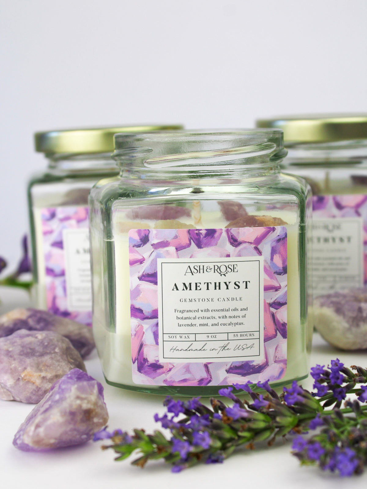 Amethyst gemstone candle in clear square glass jar with purple crystal chunks