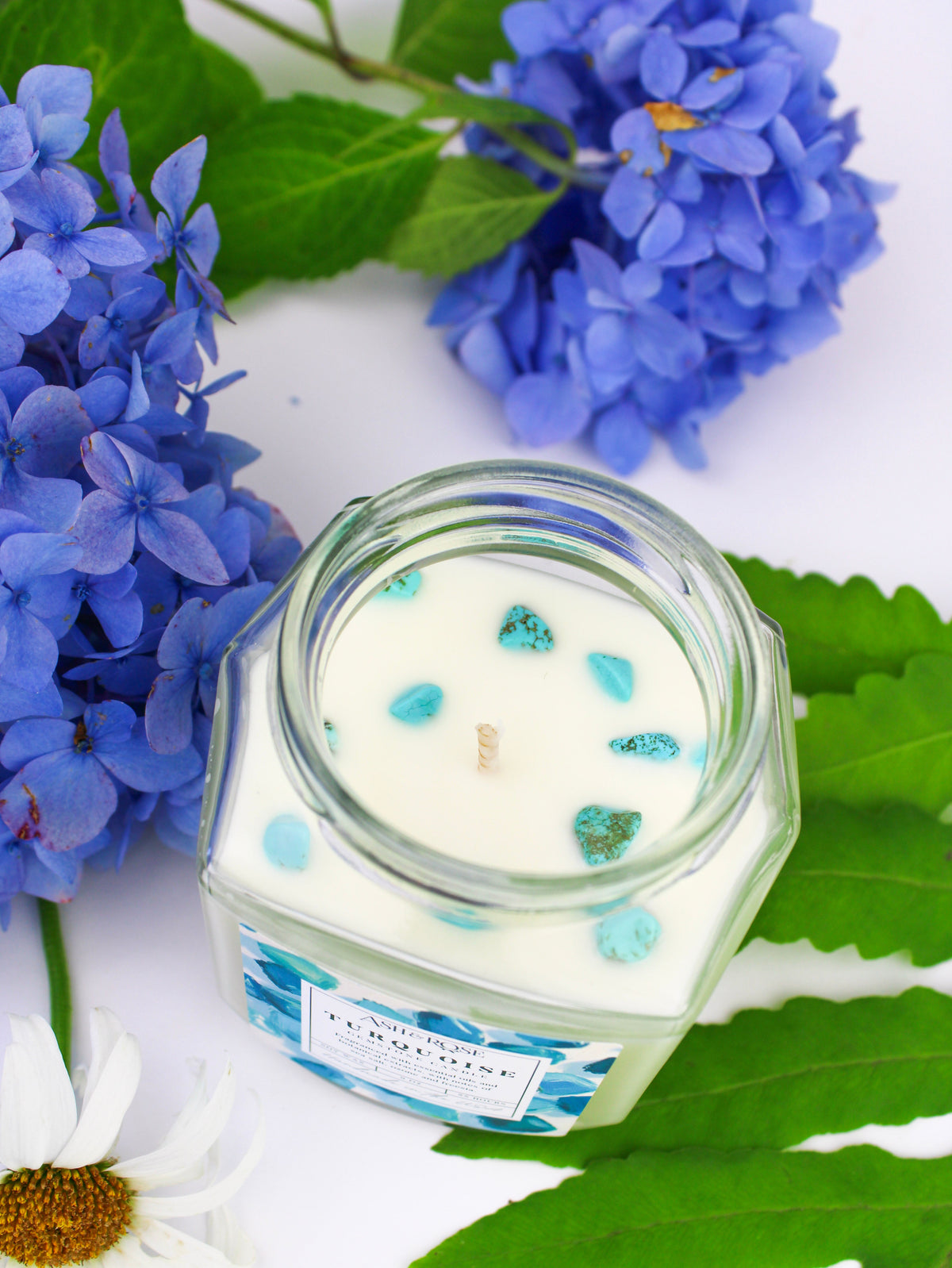 Turquoise gemstone candle in clear glass jar with blue crystal pieces