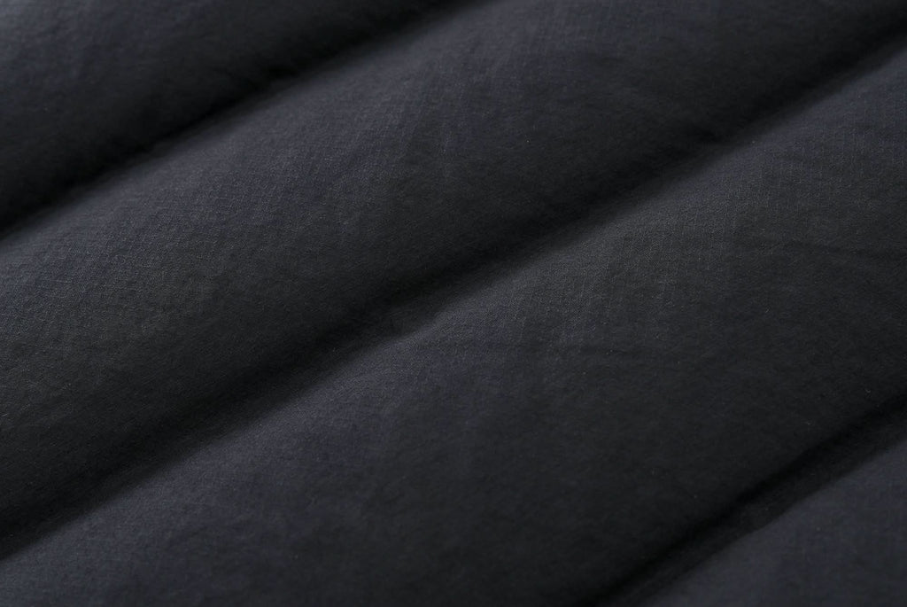 Black down jacket outer fabric close-up with quilted stitching