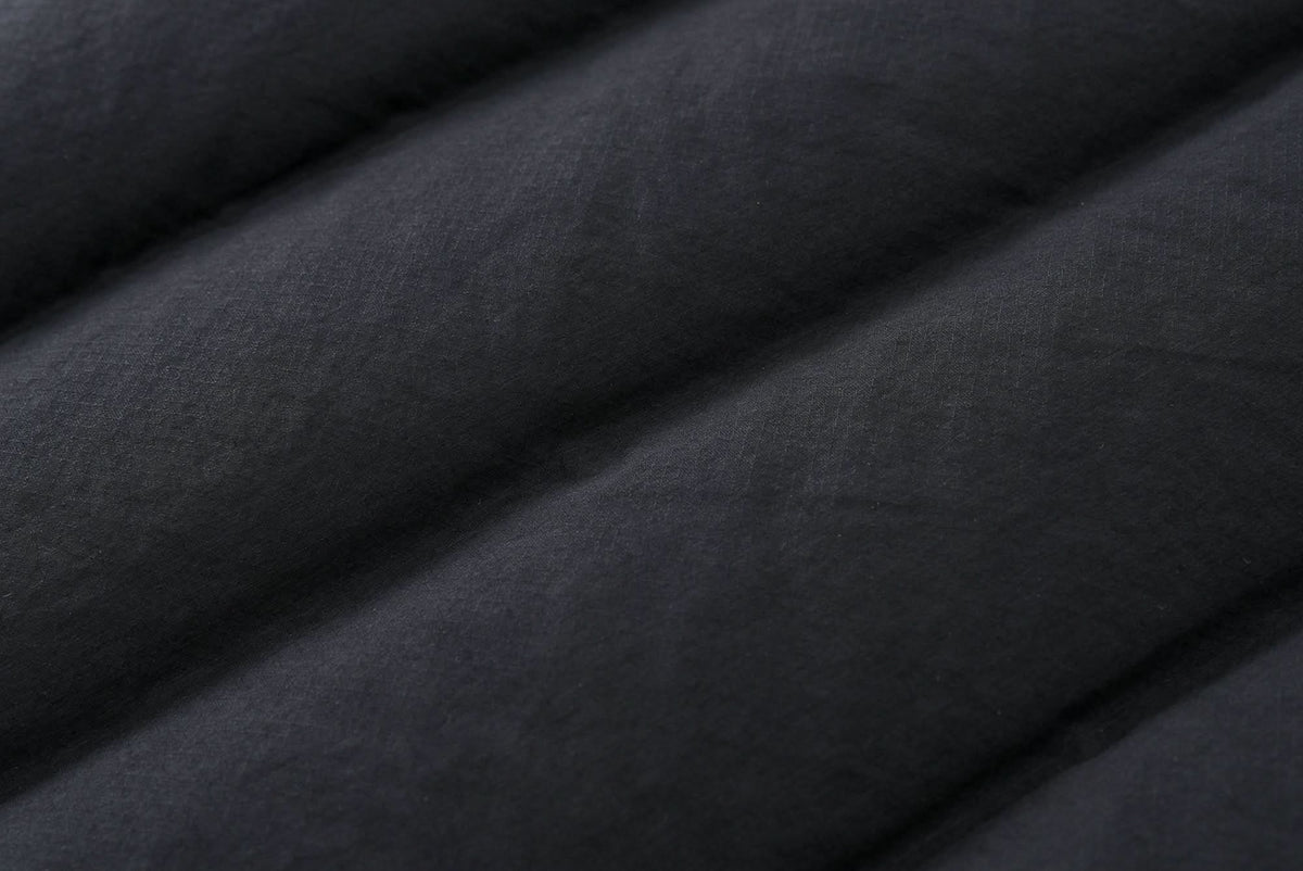 Black down jacket outer fabric close-up with quilted stitching