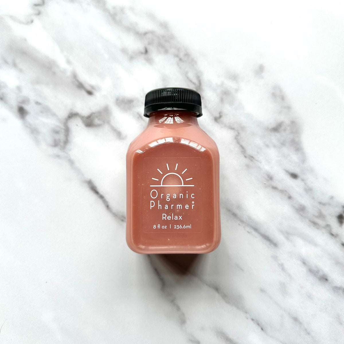 Organic Pharmere Relax beverage bottle, front view, amber pink liquid, black cap.