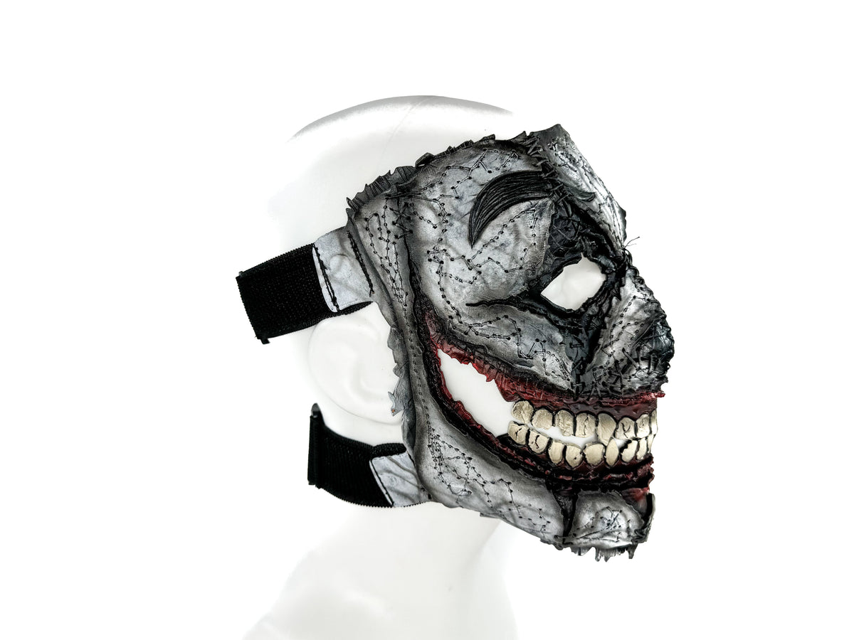 Full-face leather mask worn on mannequin head, gray distressed look, red edge stitching