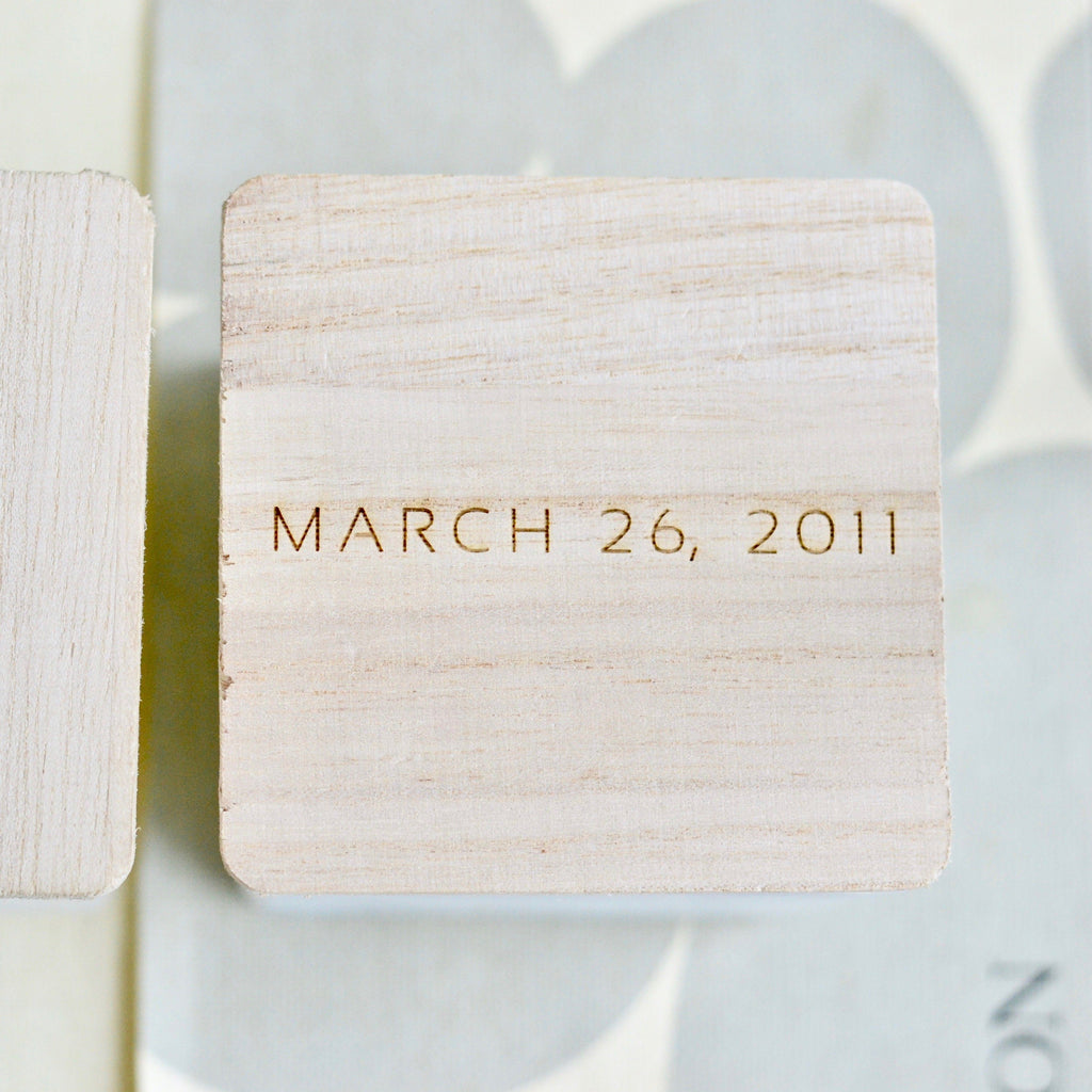 Wooden engraved tag with date MARCH 26, 2011 in black text