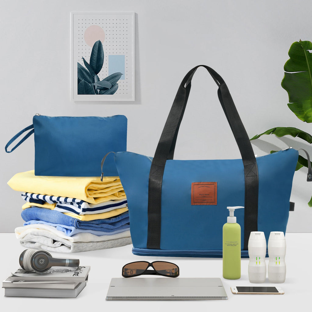 Blue duffel-style travel bag with black handles and front patch pocket