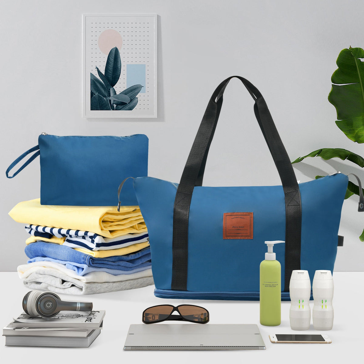 Blue duffel-style travel bag with black handles and front patch pocket