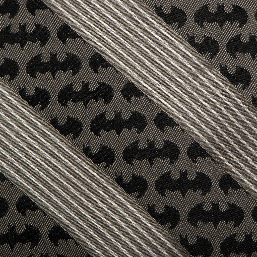 Close-up of black bat pattern and diagonal gray stripes on necktie fabric