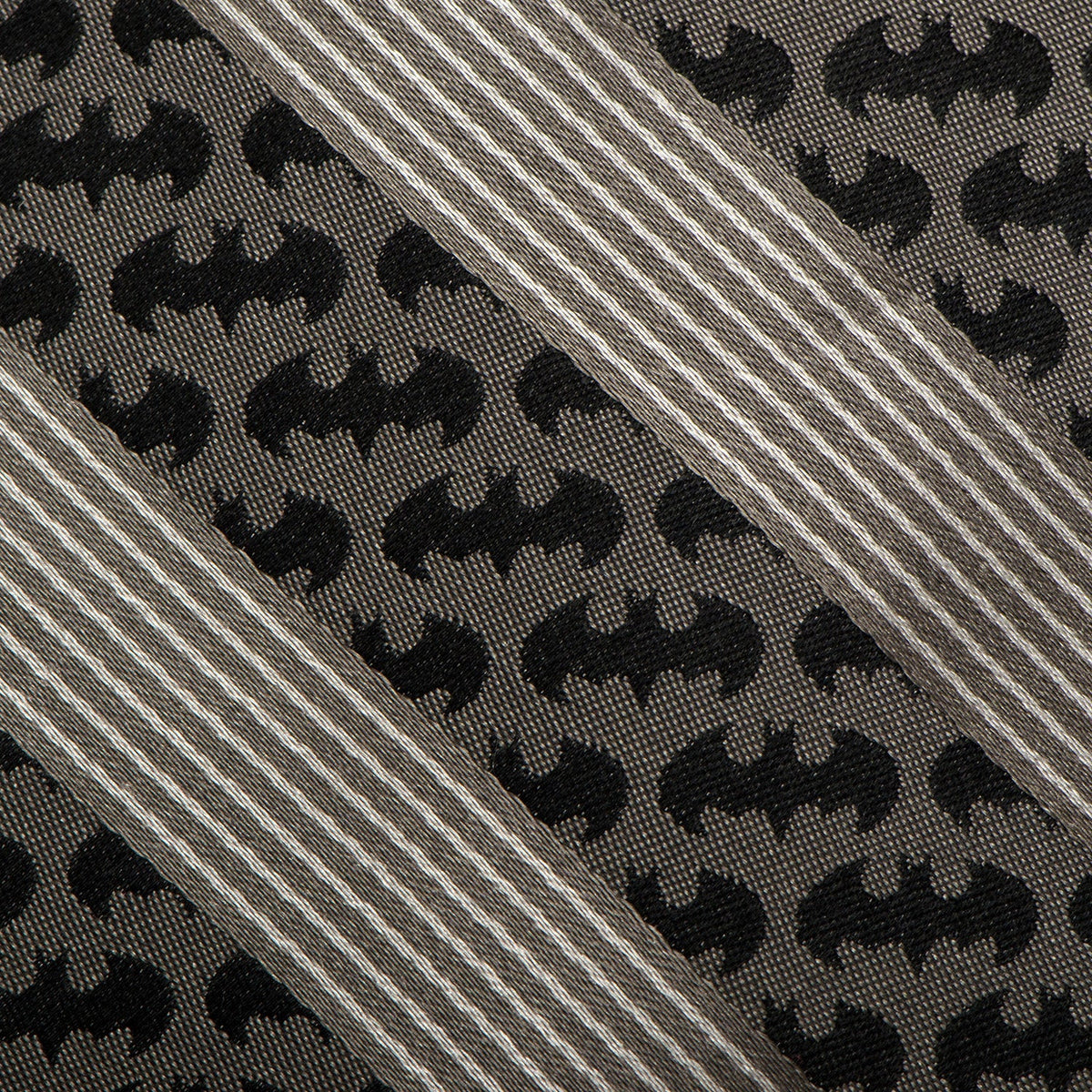 Close-up of black bat pattern and diagonal gray stripes on necktie fabric