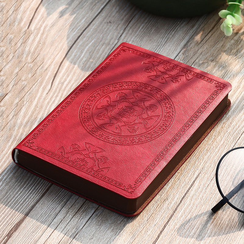 A6 leather mini notebook with embossed circular emblem on bright red cover