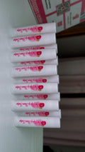 Stack of cherry lip balm chapstick tubes, white with pink-red cherry branding