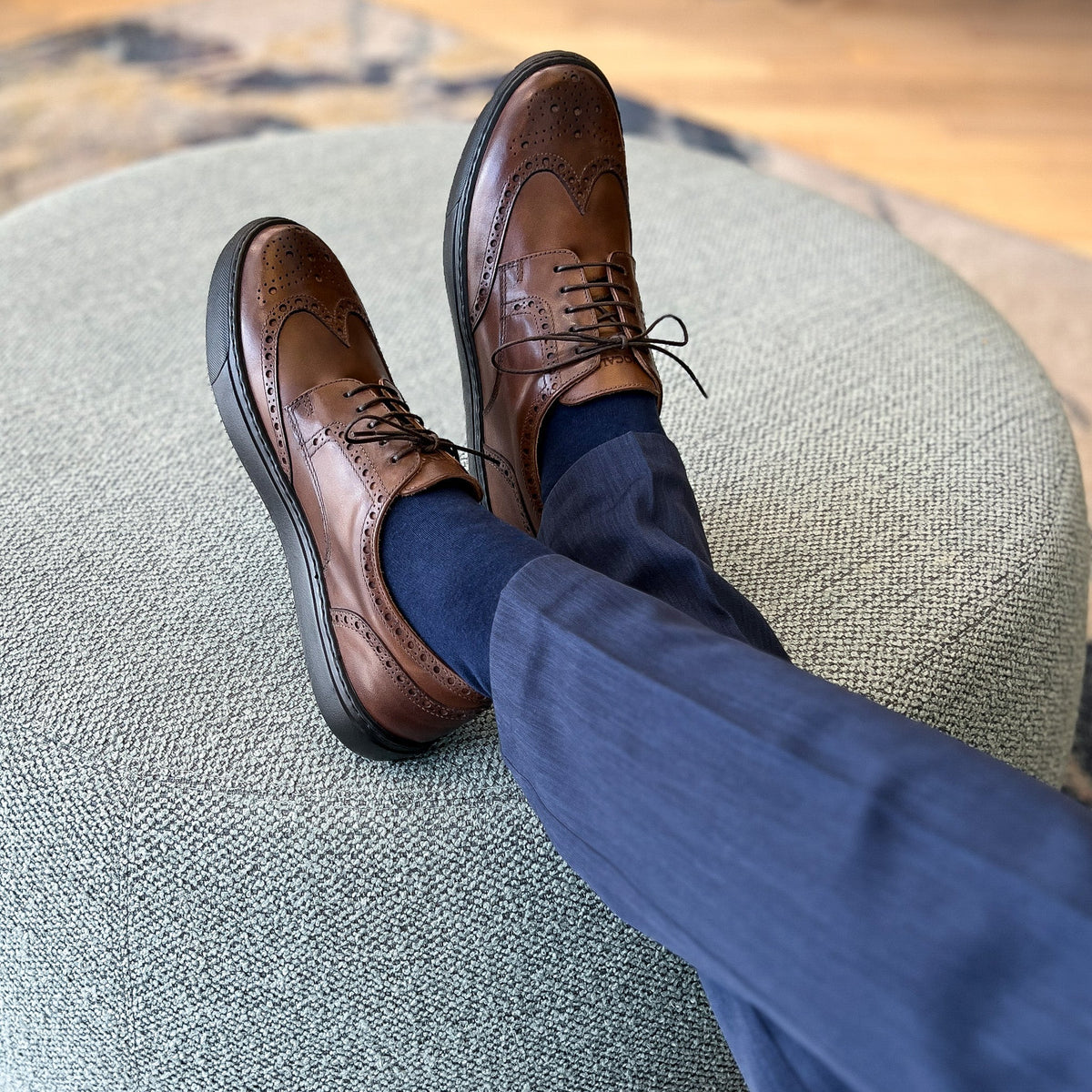 Men's brown lace-up wingtip oxford shoes shown side by side