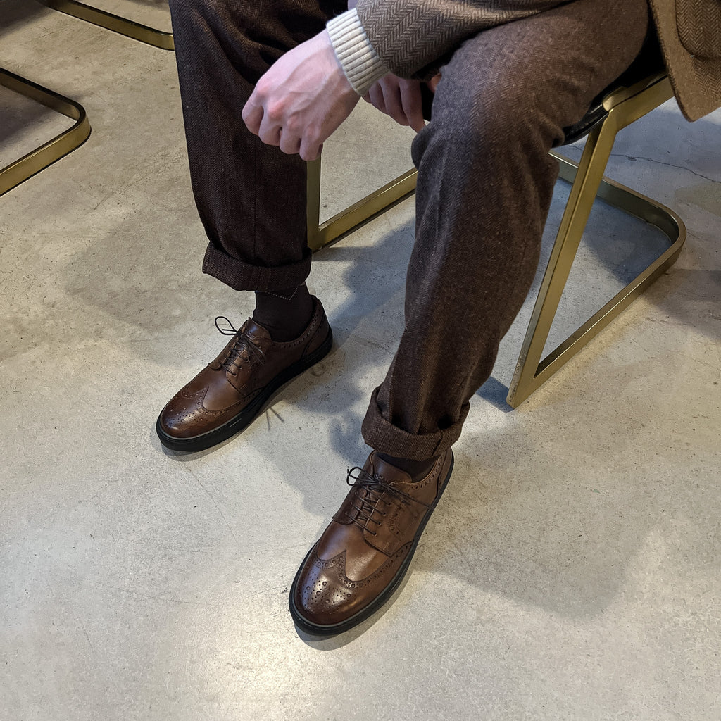 Men's brown lace-up wingtip oxford shoes with dark soles