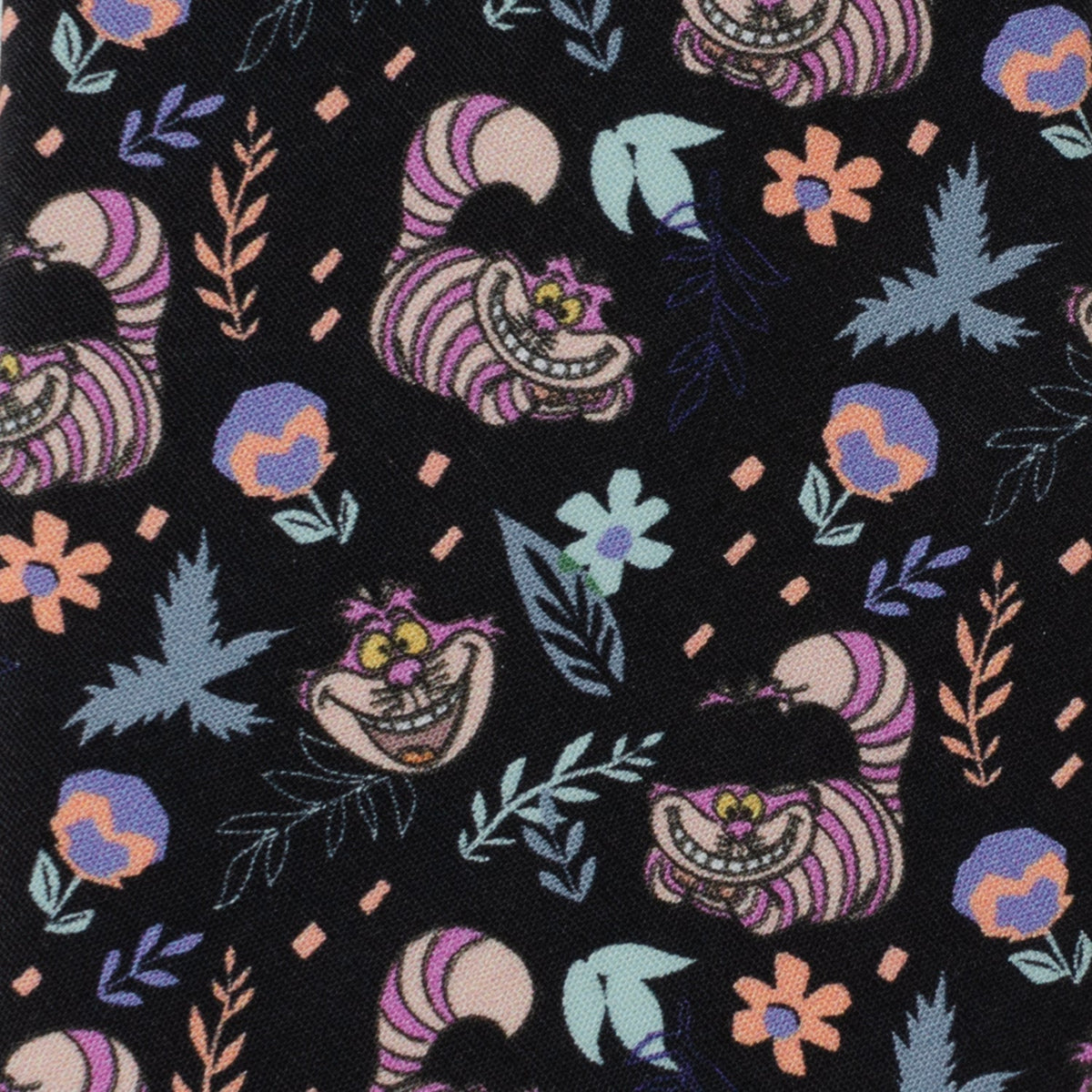 Close-up of black tie fabric with Cheshire Cat grins, flowers, and leaves