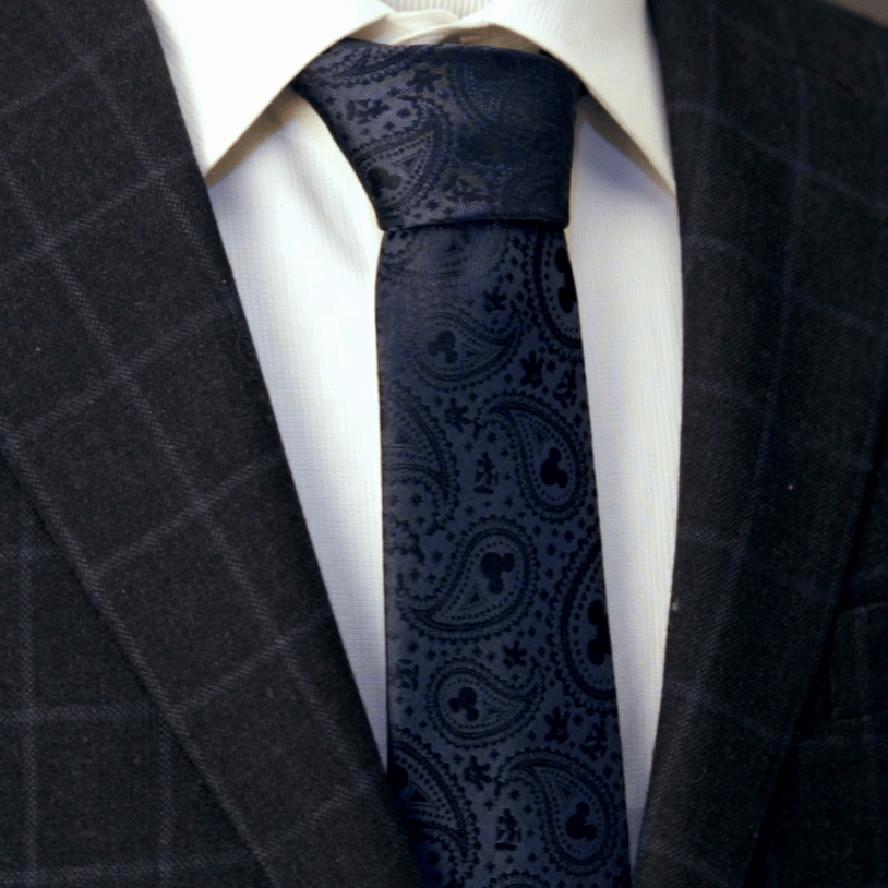 Navy paisley Mickey Mouse tie centered against white dress shirt