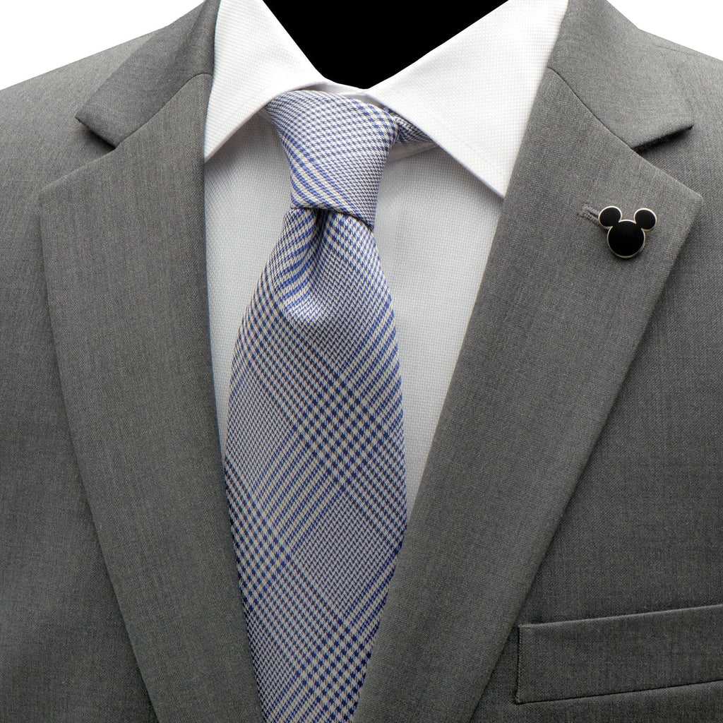Black Mickey Mouse lapel pin with silver outline on gray suit jacket