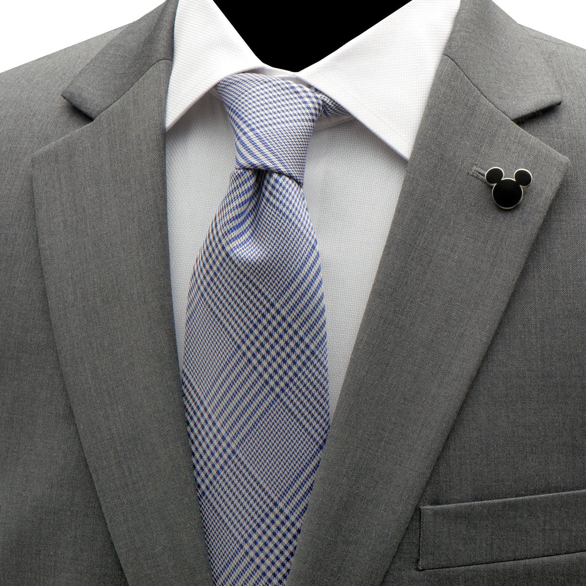 Black Mickey Mouse lapel pin with silver outline on gray suit jacket